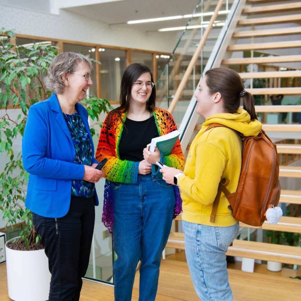 Foto Master Academie Educatie. 3 masterstudenten staan te praten voor de gang op Kapittelweg 35, Nijmegen. 