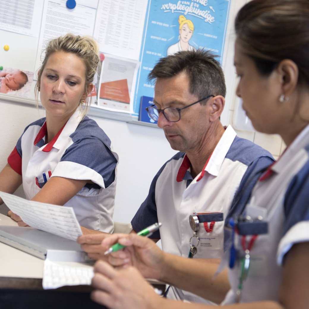 Drie verpleegkundigen tijdens de overdracht