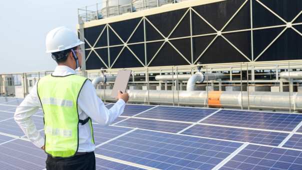 man staat in een industriele omgeving bij zonnepanelen