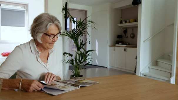 Dames leest krant in empathische woning