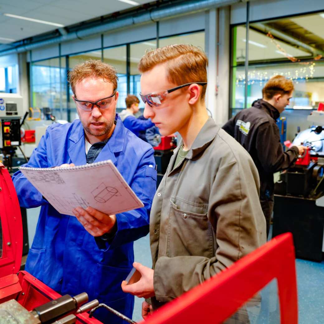 student krijgt uitleg bij machine