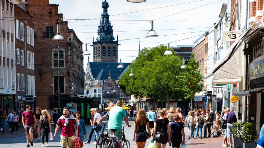 Nijmegen mensen in winkelstraat met kerk op achtergrond