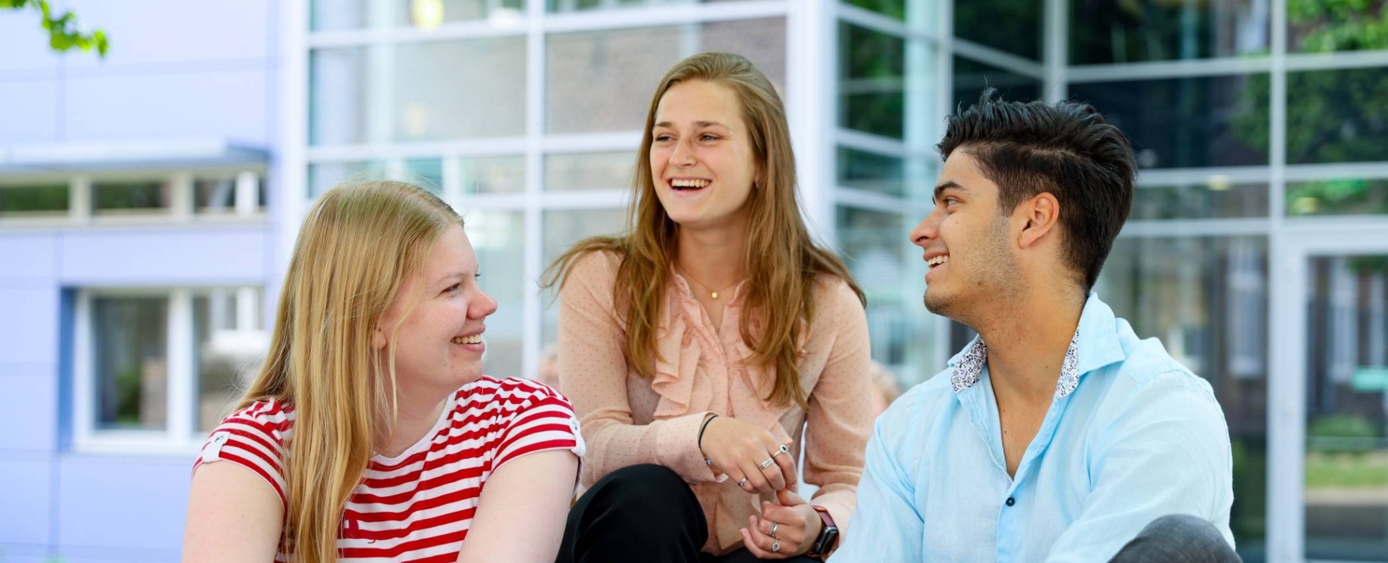 Drie studenten van hbo Bedrijfskunde buiten bij de HAN campus