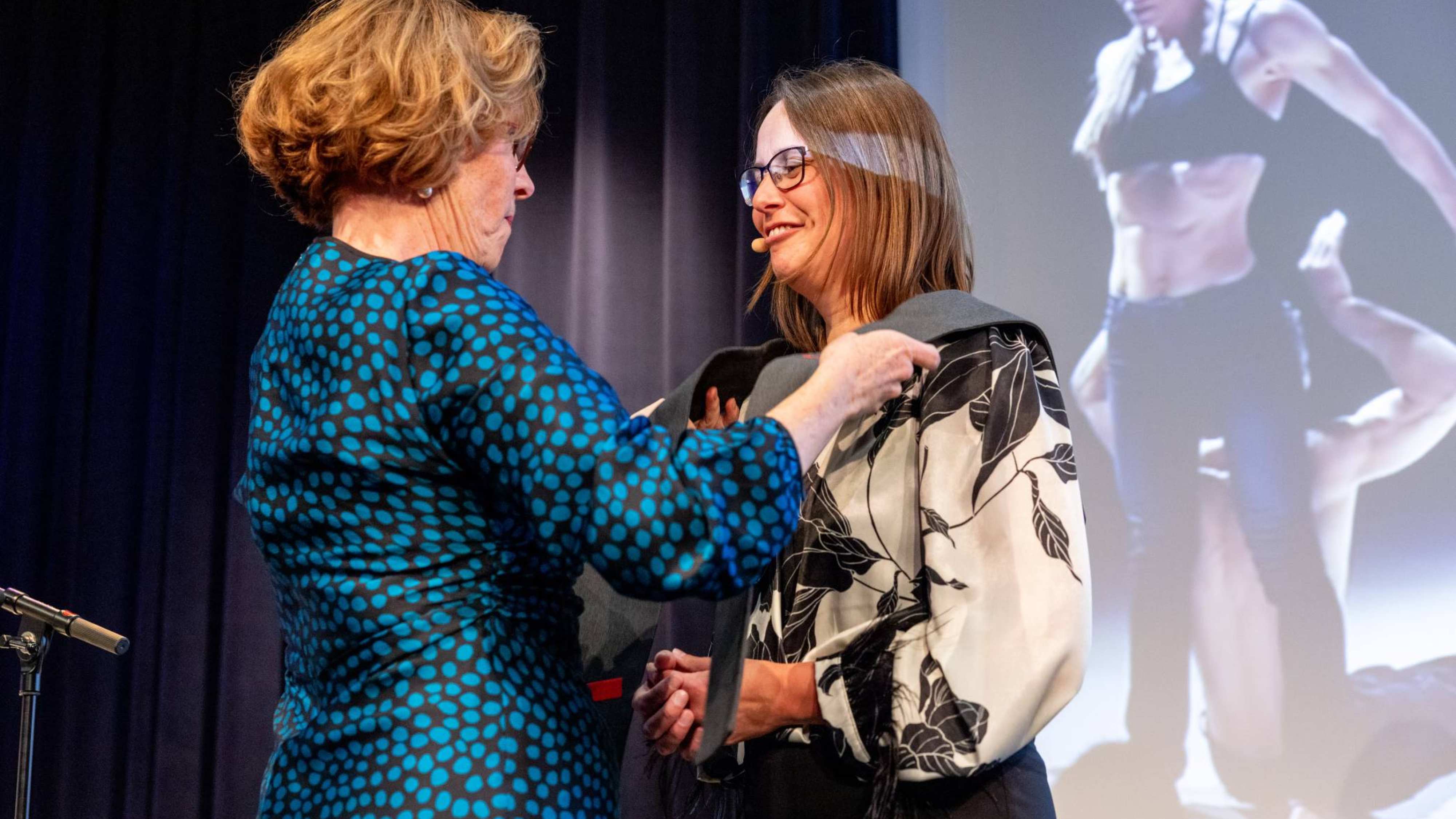 Bridget Kievits hangt de stola om bij Wietske Kuijer bij haar installatie als lector