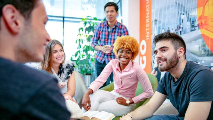 Groep studenten in gesprek lachend