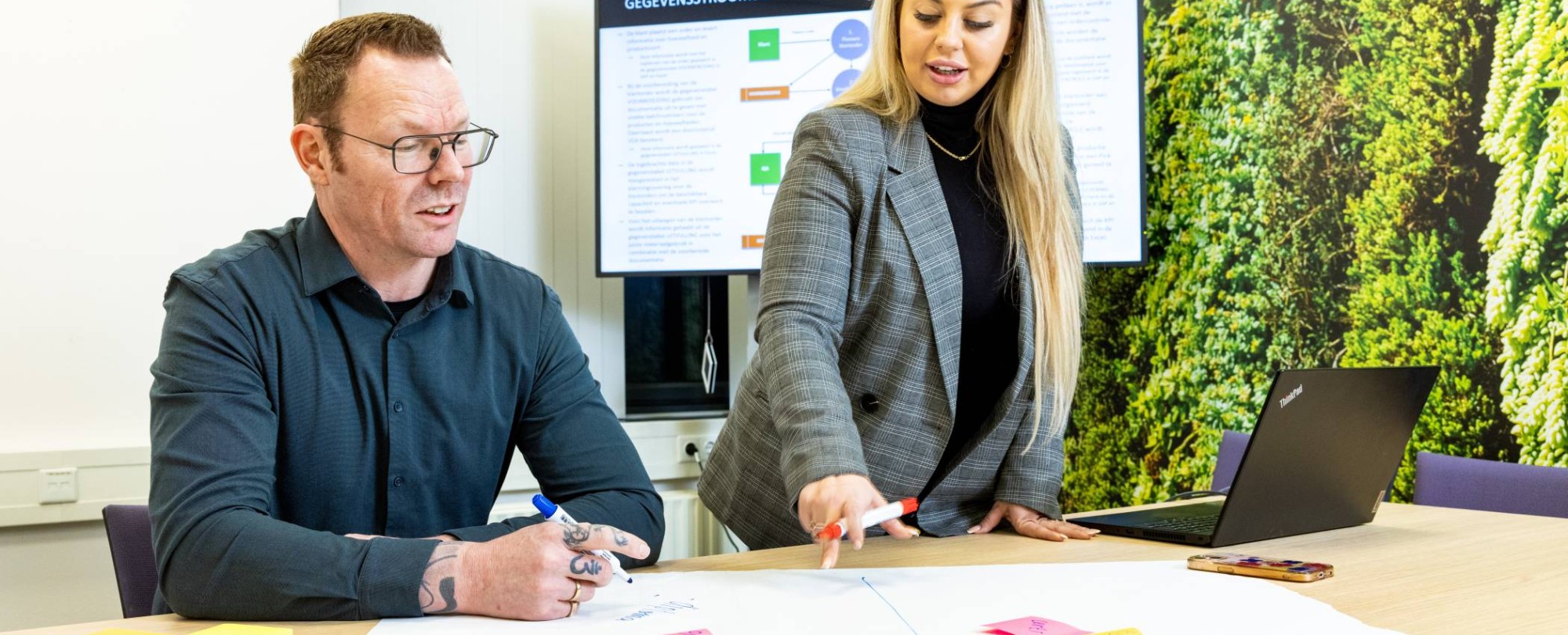 twee studenten van hbo logistiek deeltijd werken samen aan een opdracht met post-its