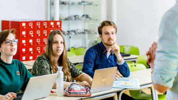 Student in de klas stelt vraag aan docent