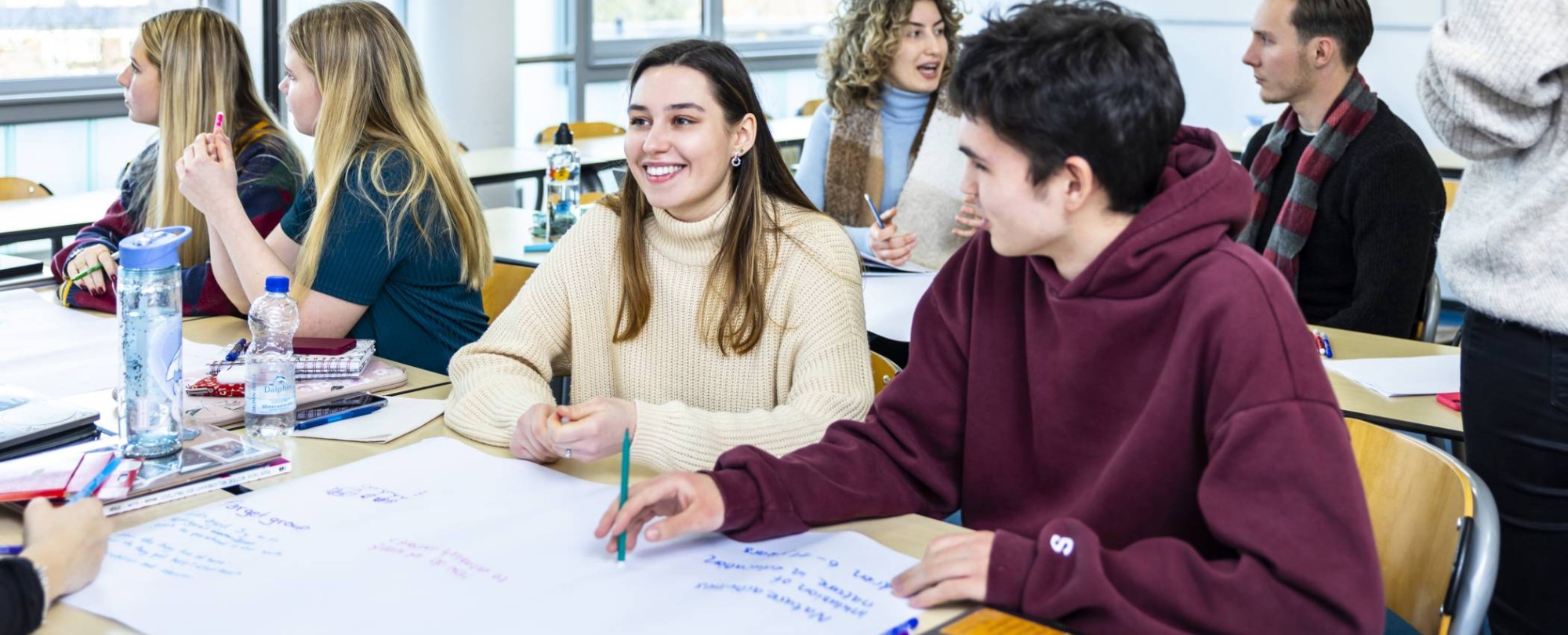 International Social Work. Studenten in collegebanken met praatplaat op tafel