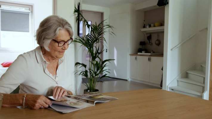 Dames leest krant in empathische woning