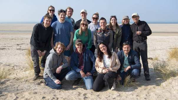 Groepsfoto van Leraar Aardrijkskunde studenten op het strand na het uitvoeren van veldwerk.