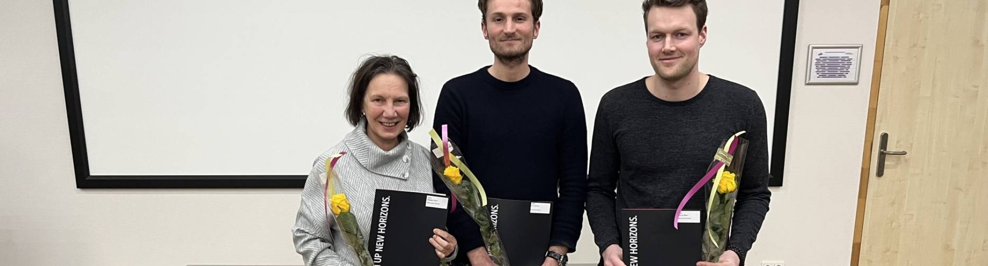 Foto van drie afgestudeerde Masterstudenten uit de Academie Educatie met hun diploma's 