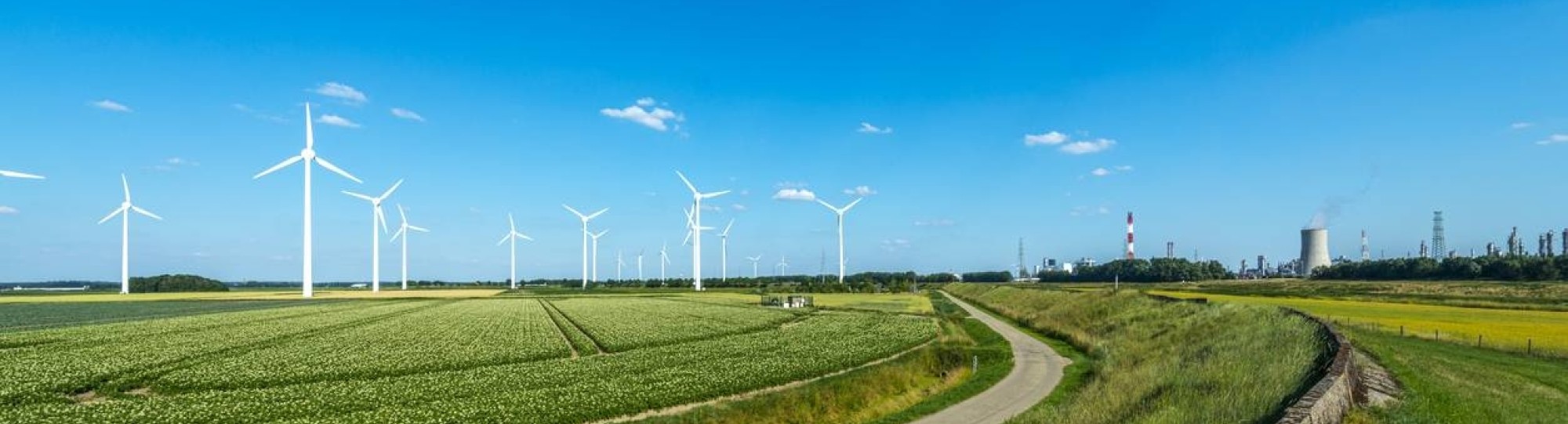 Nederlands landschap met blauwe lucht, windmolens en energiecentrale