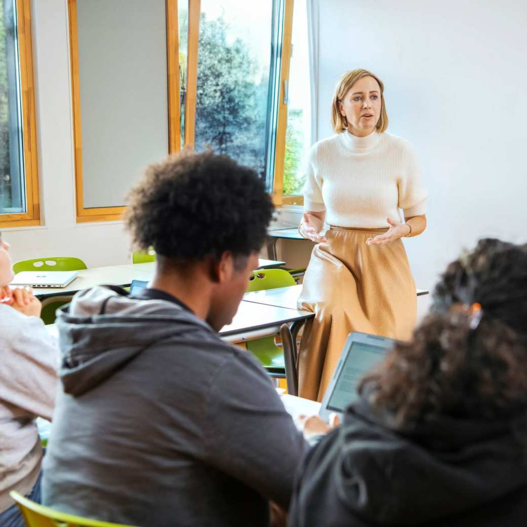 docent staat voor 3 masterstudenten en geeft uitleg