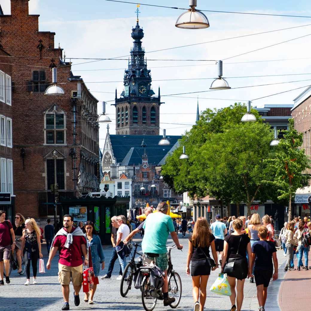 mensen in winkelstraat met kerk op achtergrond