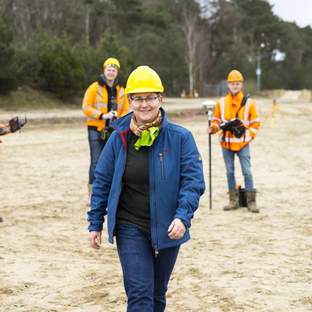 vrouw met gele helm op bouwplaats