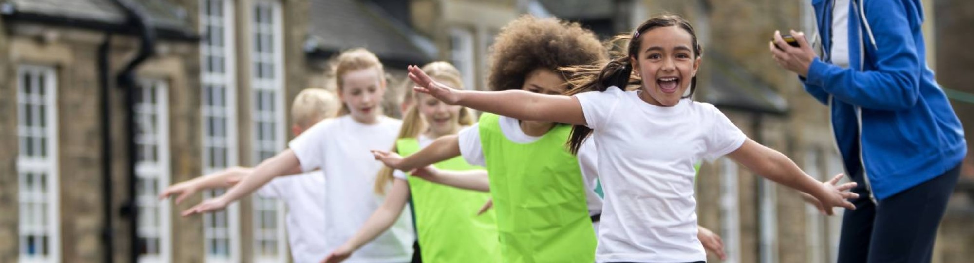 kinderen met de armen wijd aan het spelen op het schoolplein