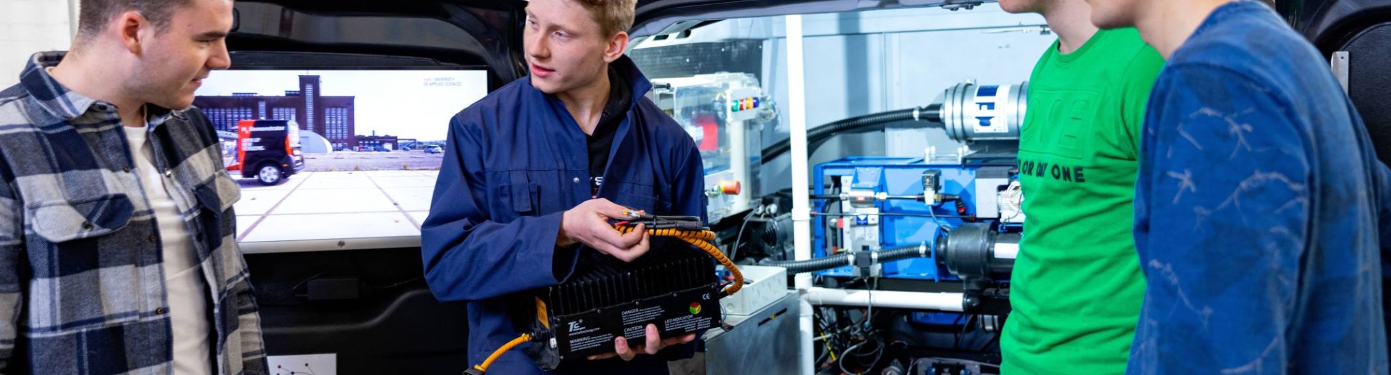 4 studenten voor de schterkant van de h2 demonstrator