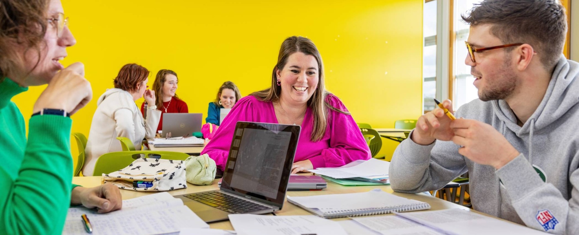 De studenten lachen in het klaslokaal. 