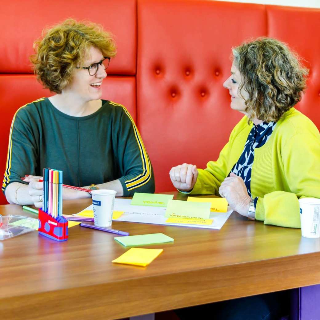 twee docenten vergaderen lachend