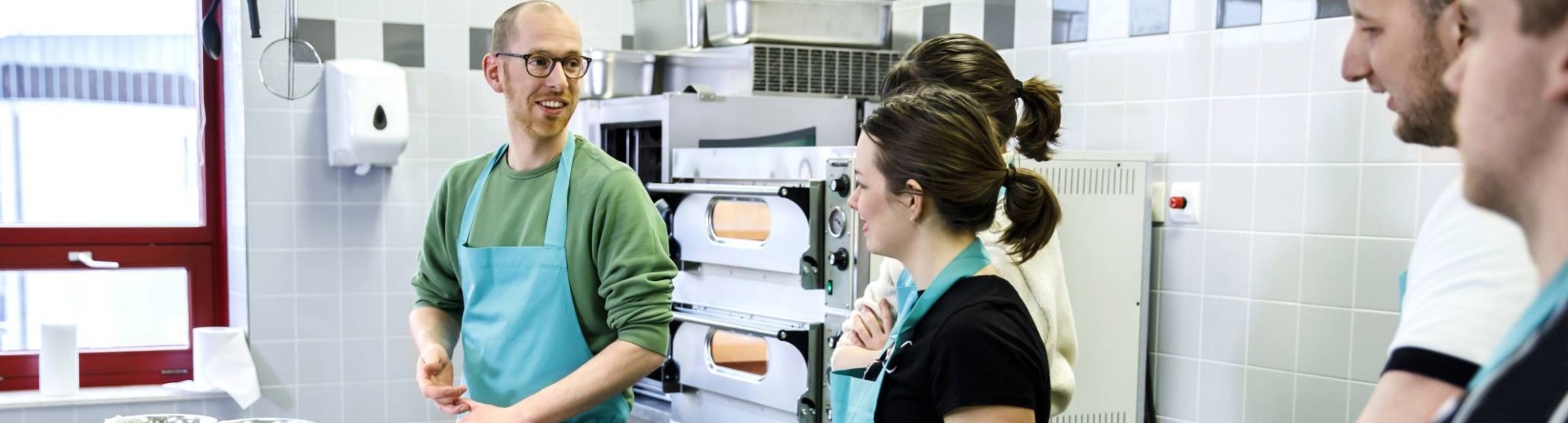 studenten en docent in de keuken