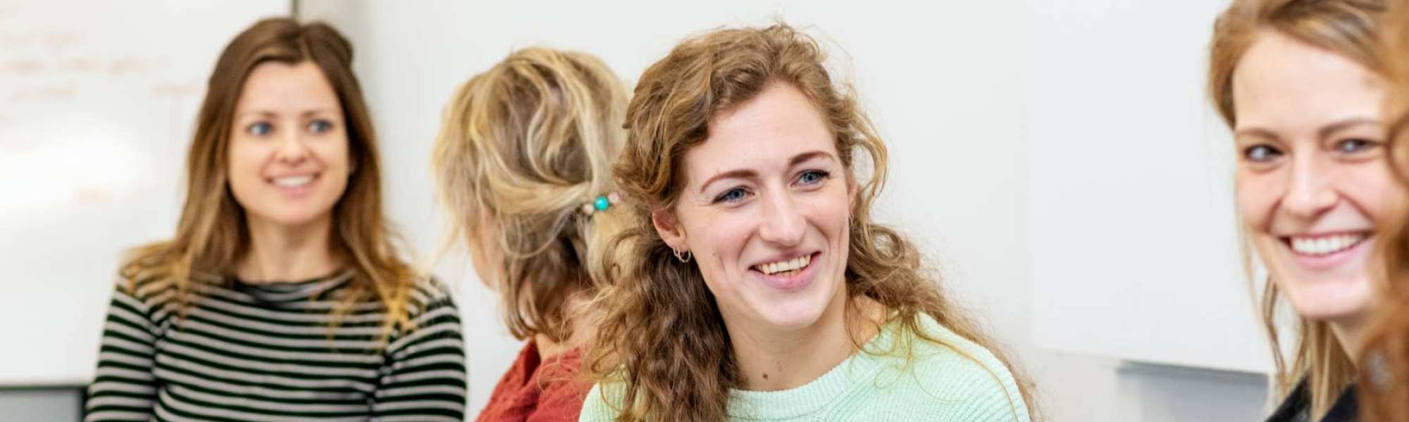 ALLEEN VOOR DE MANP | Lachende masterstudenten overleggen samen tijdens een klassikale les onderzoek op de HAN in Nijmegen.