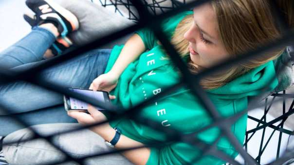 foto van student Meike Geurtsen die op haar telefoon kijkt.