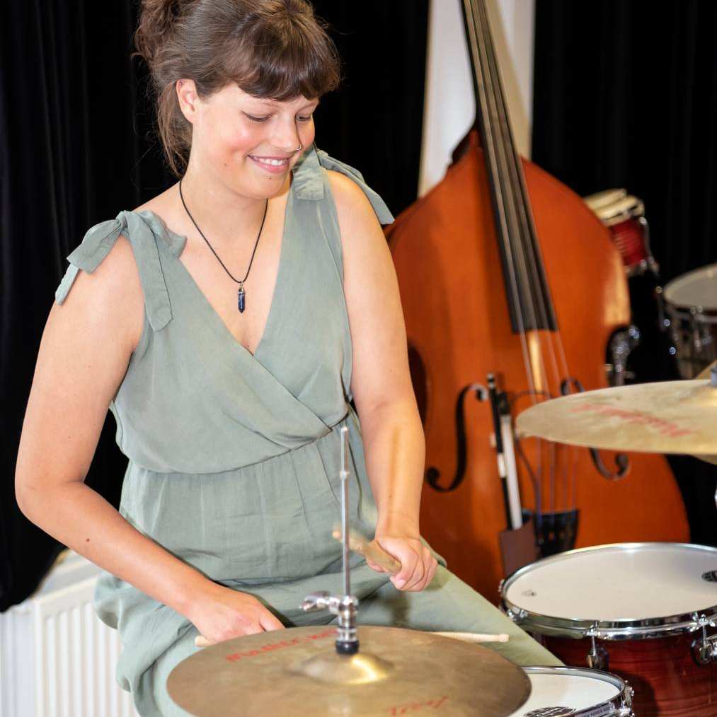 Studente muziektherapie speelt op de drums in een praktijklokaal