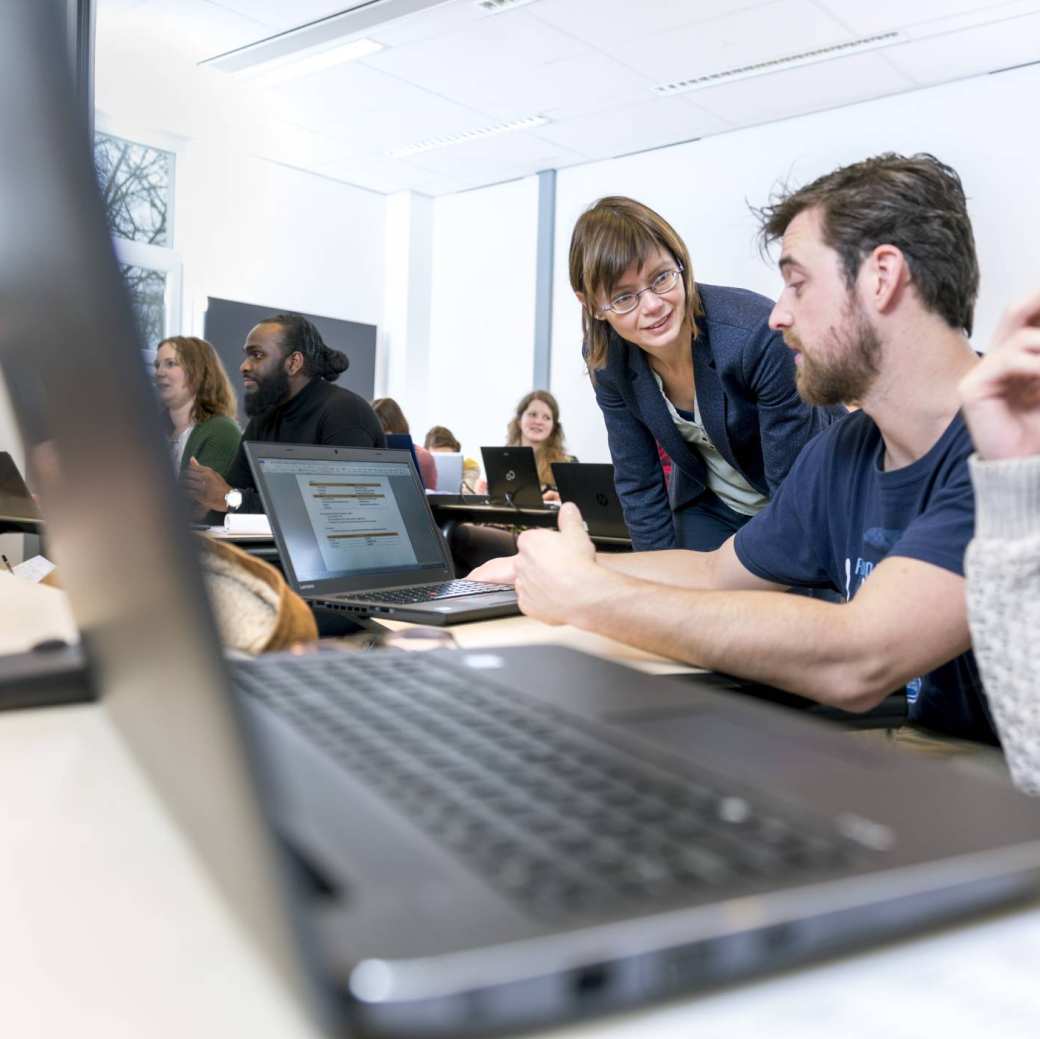 docent andrea thiele overlegt met man met baard en laptop