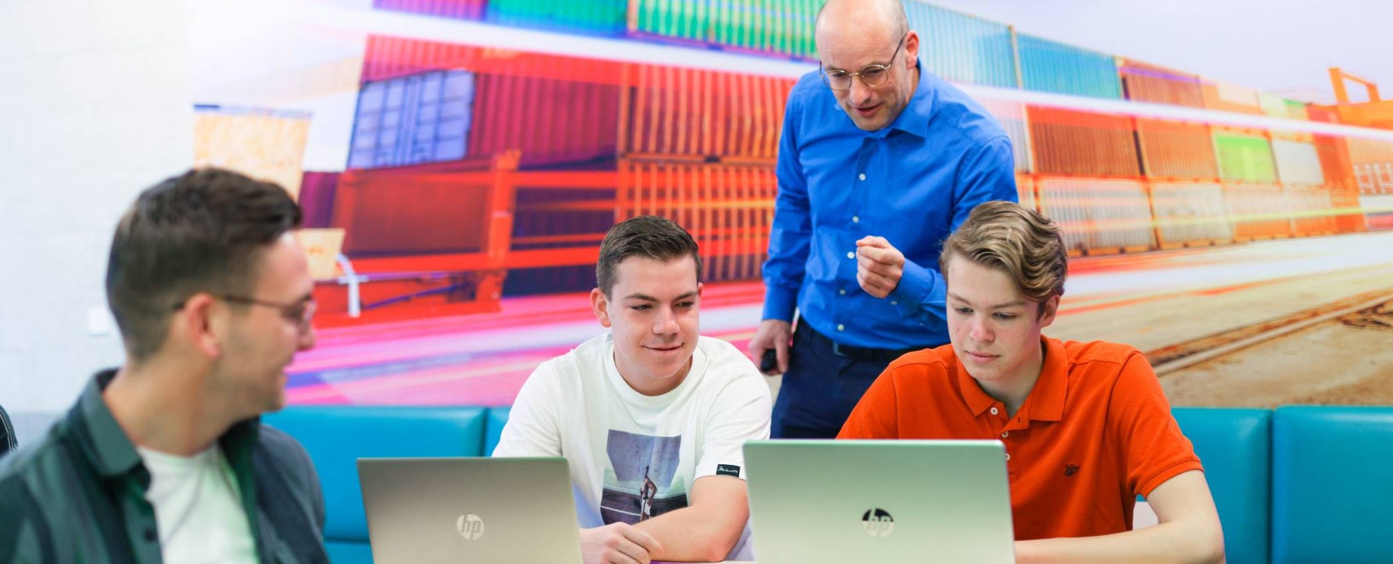 Logistics Management voltijd, LM, foto 7792, docent geeft uitleg aan tafel bij studenten in het lokaal