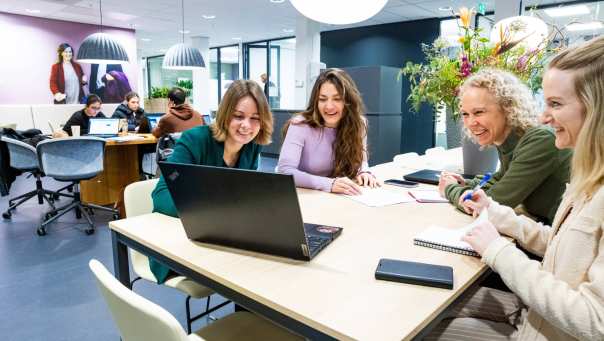 Post-hbo Bedrijfskunde, deelnemers werken samen aan een opdracht met laptop. 