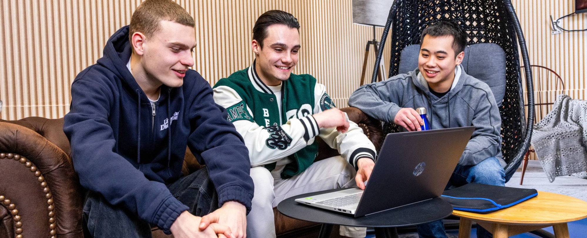 Studenten bachelor Logistics Management voltijd overleggen met de laptop erbij