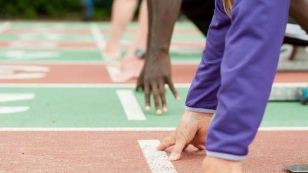 mensen bij de startstreep op een atletiekbaan