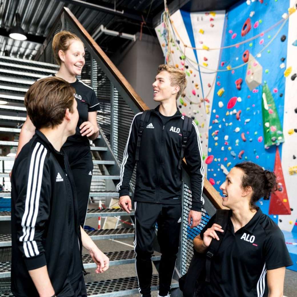 4 Pabo-ALO studenten staan op de trap te kletsen in hun ALO-outfit.