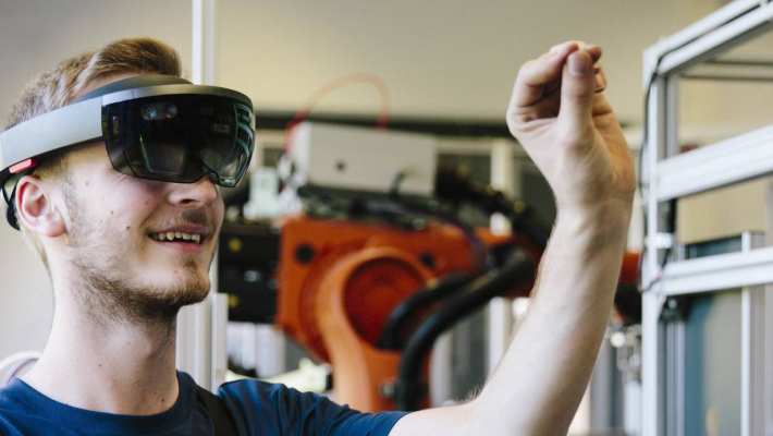 Man / student werkt met AR bril op. Virtual reality in een productieomgeving