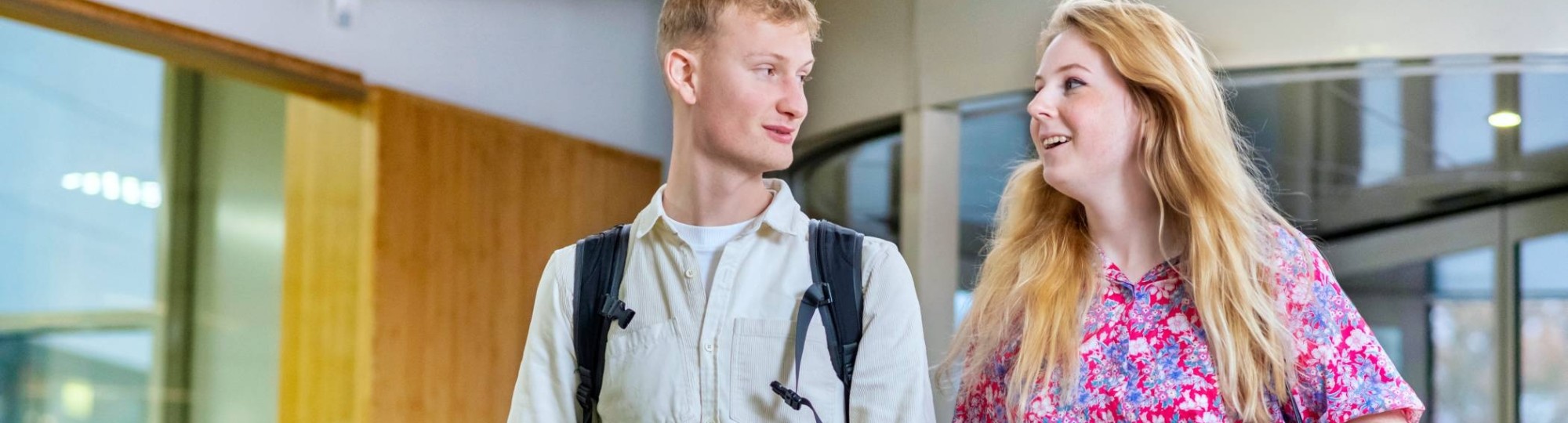 Studenten lopen lachend door de gang