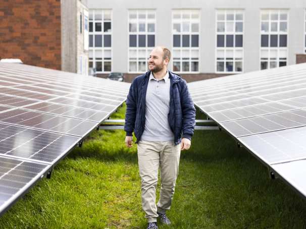 man lopend tussen energiepanelen