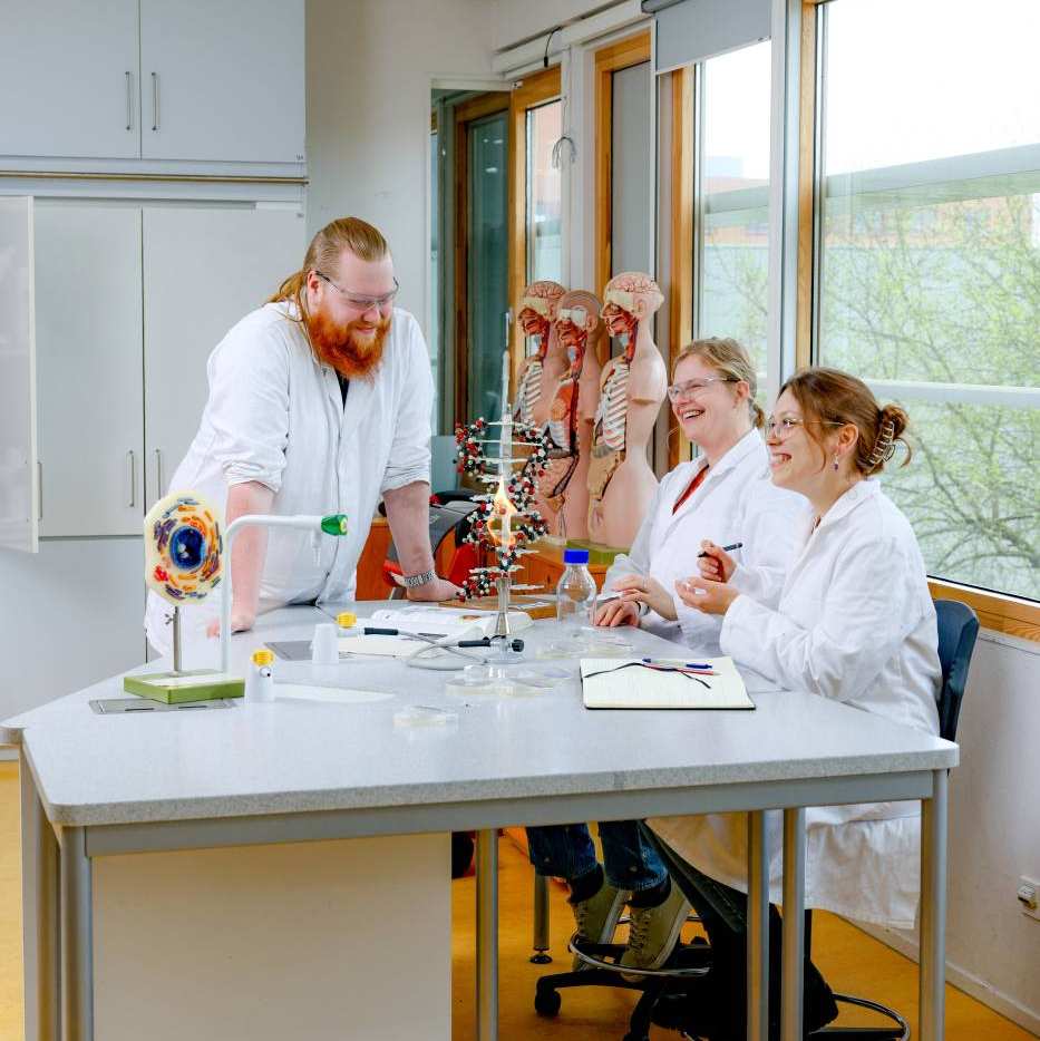 Docent en studenten in het lab en ze lachen breed.