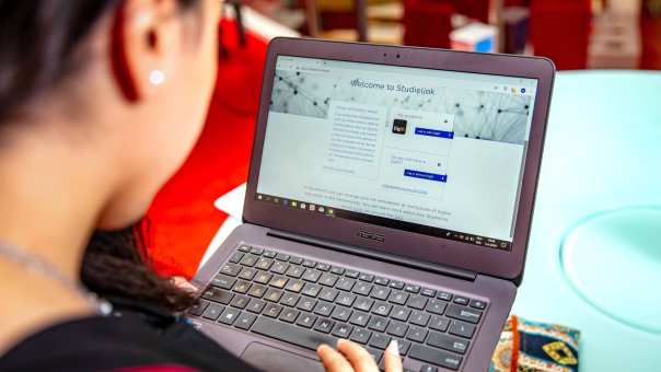 Student achter laptop met Studielink pagina