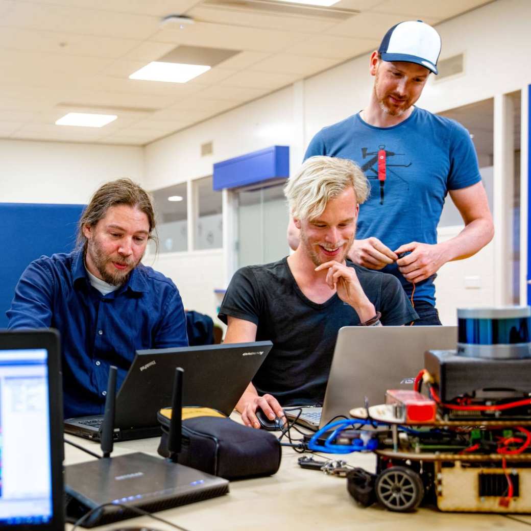 Groep studenten werkt samen aan zelfrijdende auto met laptop