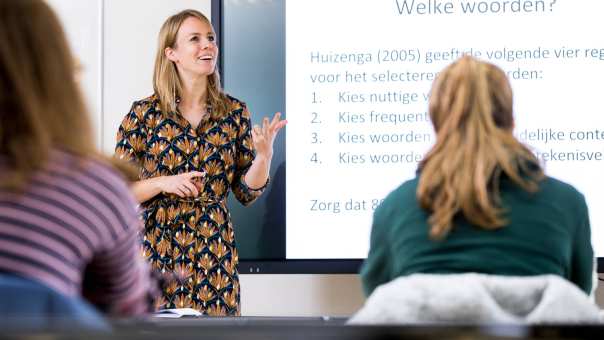 ALPO leraar staat voor de klas en telt op haar vingers