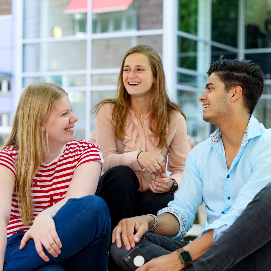 Students sitting outside at Arnhem campus of HAN University of Applied Sciences