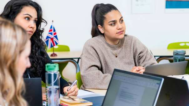 Twee cursisten voor de Cambridge Examentraining luisteren naar de docent.