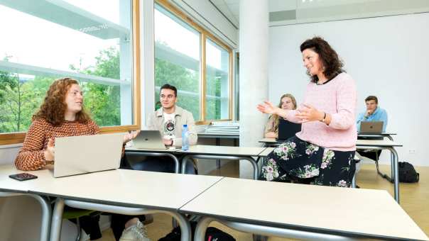 Pabo-ALO studenten zitten samen met een docent die hun lesgeeft in het Pabo lokaal.