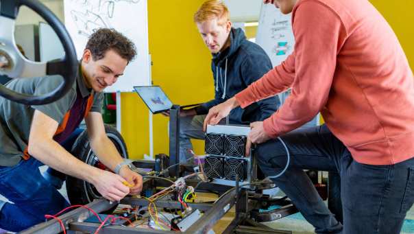 Drie studenten werken aan waterstofvoertuig eenpersoon IPKW H2lab Waterstoflab