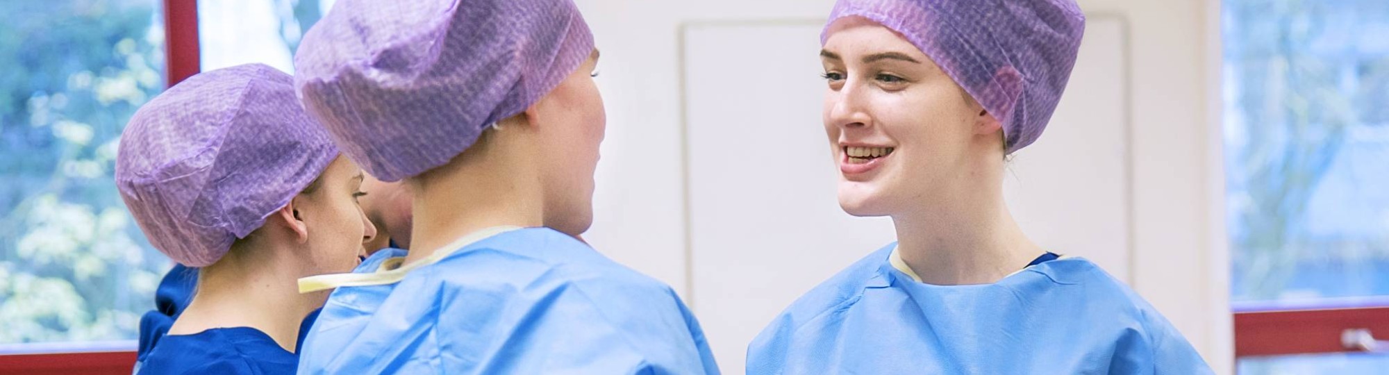 Studenten Medische Hulpverlening in operatiekleding lachen