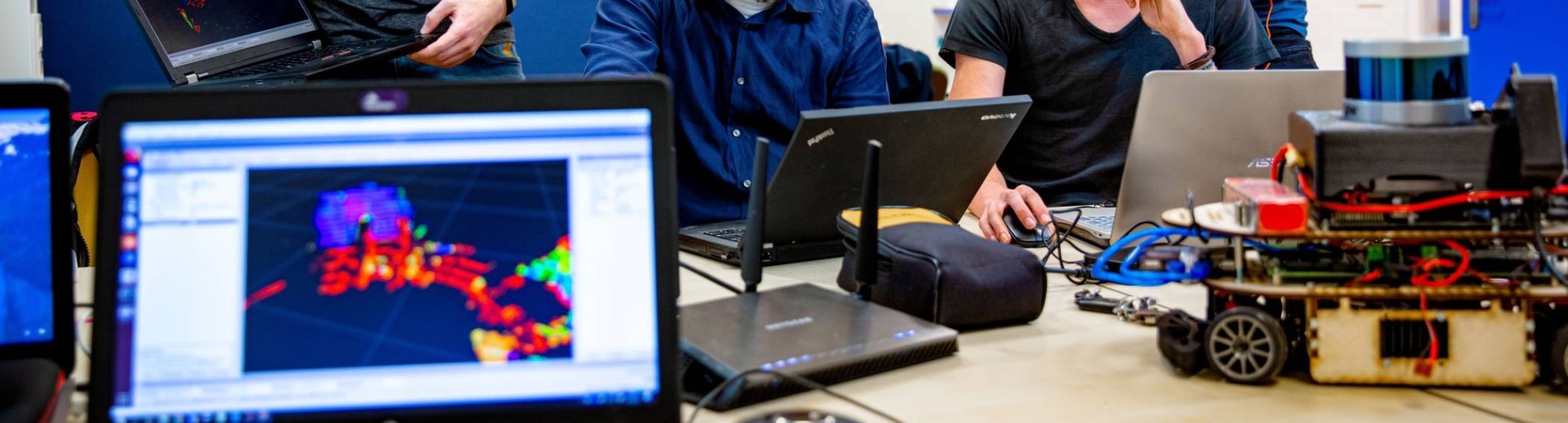 Groep studenten werkt samen aan zelfrijdende auto met laptop