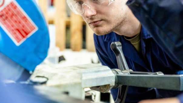 Two students working on an engineering machine for Mechanical Engineering - Werktuigbouwkunde - wearing glasses