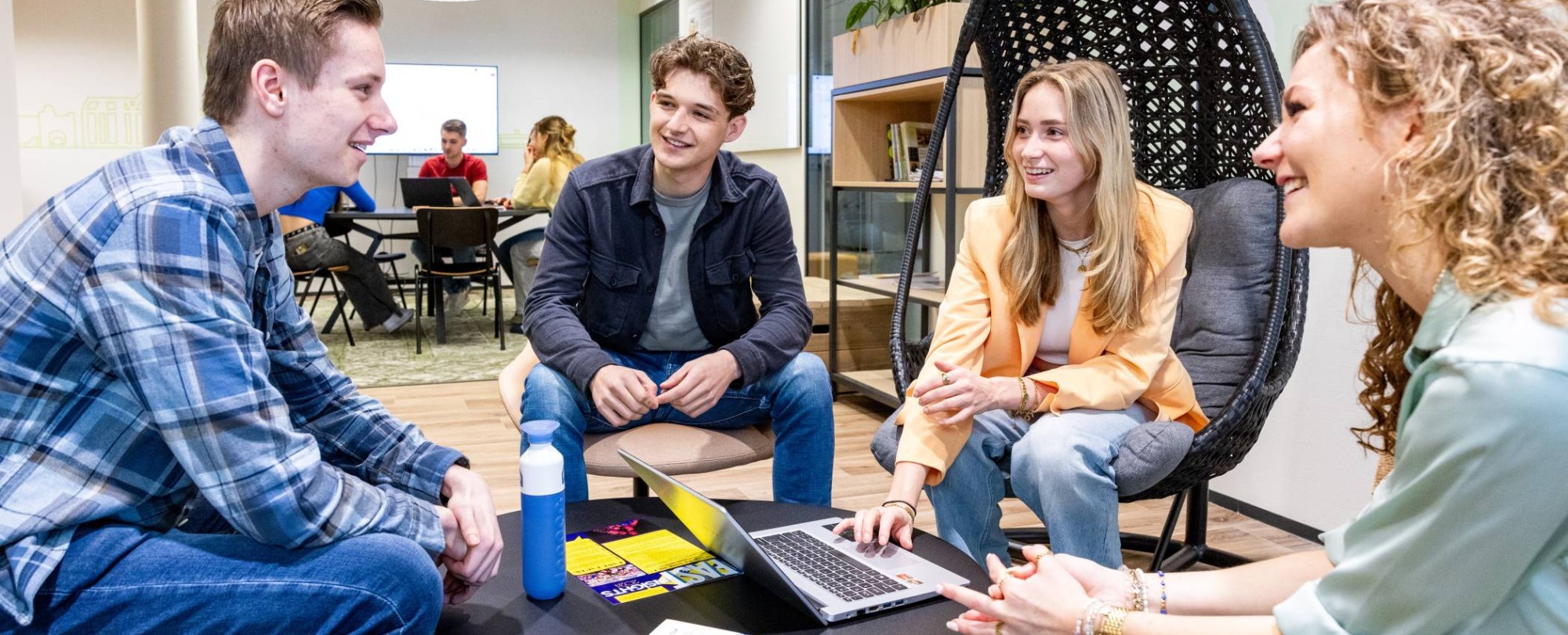 Studenten Facility Management hebben overleg met een laptop erbij