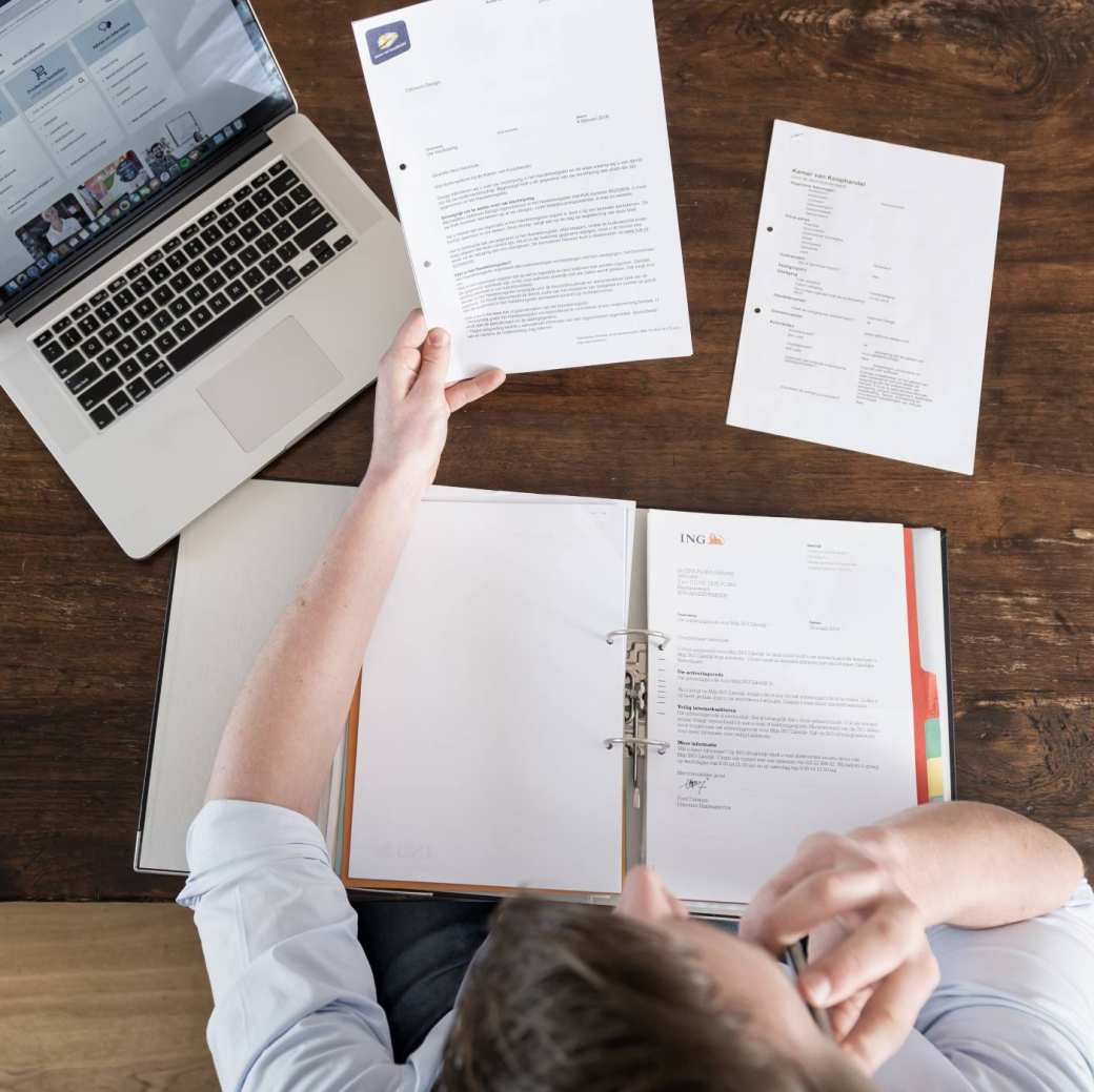 Man leest overheidsbrieven aan tafel 