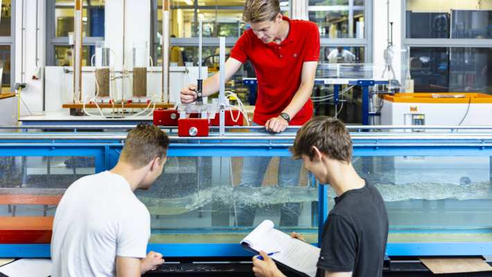 drie studenten simuleren in het waterlab situaties voor civiele techniek waterbouwkunde 